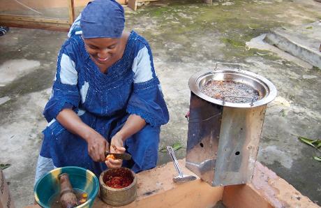 Frau in Nigeria mit Brennholzkocher